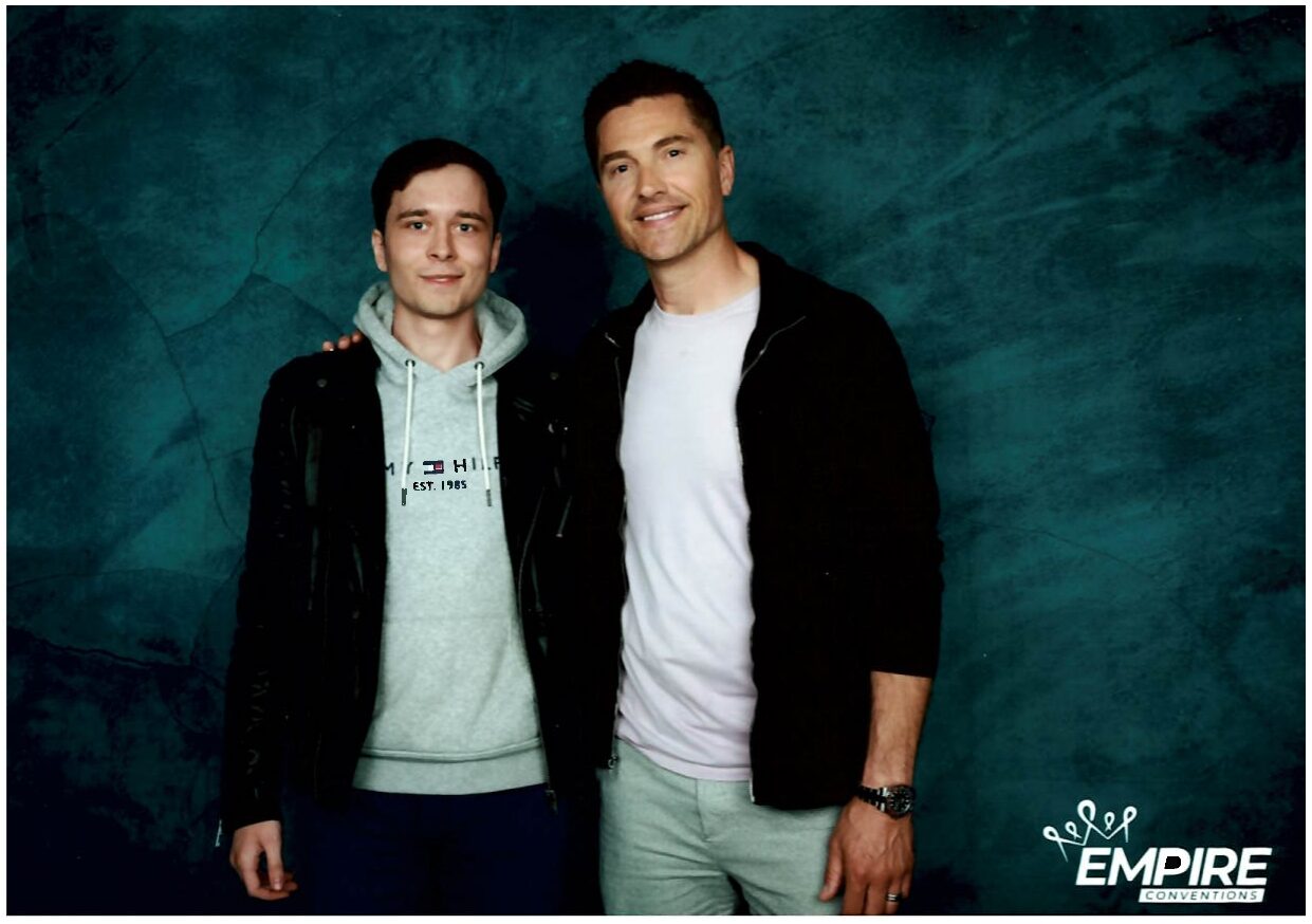 Dagomir Wójcik and Eric Winter smiling at the camera.